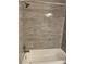 A tiled shower and tub with a modern shower head at 2564 Woodgate Blvd # 102, Orlando, FL 32822
