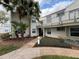 Condominium exterior featuring the building, sidewalk, manicured landscaping and healthy mature palm trees at 2564 Woodgate Blvd # 102, Orlando, FL 32822