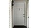 Close up of the condo's front door with a peep hole and overhead light fixture at 2564 Woodgate Blvd # 102, Orlando, FL 32822