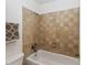 Close-up of a bathtub and shower featuring decorative tile work and fixtures at 2635 Graduate Ct, Orlando, FL 32826