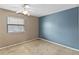 Carpeted bedroom with window view and painted accent wall at 2635 Graduate Ct, Orlando, FL 32826