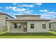 Rear of home featuring a covered patio and lush green lawn at 2811 Alpine Meadow Ln, Kissimmee, FL 34744