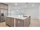 Kitchen island with sink in open floor plan features stainless fridge and backsplash at 2811 Alpine Meadow Ln, Kissimmee, FL 34744