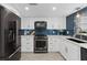 Modern kitchen with stainless steel appliances, white cabinets, a tile backsplash, and bright recessed lighting at 3104 Harrison Ave # A6, Orlando, FL 32804