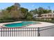 Community pool featuring a unique shape, brick trim, and surrounded by well-maintained landscaping and a secure fence at 3104 Harrison Ave # A6, Orlando, FL 32804