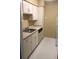 Functional kitchen with white cabinets, sink, dishwasher, and laminate flooring at 315 Wymore Rd # 207, Altamonte Springs, FL 32714