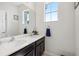 Bathroom featuring double sinks with dark cabinets and quartz countertop under a large mirror at 3953 Saltmarsh Loop, Sanford, FL 32773