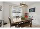 Cozy dining area with a wooden table, bench seating, and a stylish light fixture at 3953 Saltmarsh Loop, Sanford, FL 32773