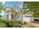 Charming two-story home with a white exterior, a brick driveway and lush landscaping at 3953 Saltmarsh Loop, Sanford, FL 32773