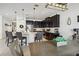 Open-concept kitchen featuring dark cabinetry, a breakfast bar, and stainless steel appliances at 3953 Saltmarsh Loop, Sanford, FL 32773