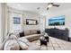 Bright living room with a plush gray sectional, patterned rug, and sleek entertainment console at 3953 Saltmarsh Loop, Sanford, FL 32773