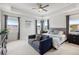 Bright main bedroom with tray ceiling, complemented by a cozy sitting area and large windows at 3953 Saltmarsh Loop, Sanford, FL 32773