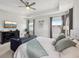 Comfortable bedroom with tray ceiling, ceiling fan, mounted TV, and sitting area at 3953 Saltmarsh Loop, Sanford, FL 32773