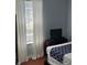 Bedroom includes a window with curtains, TV on a wood cabinet, and a patterned bedspread at 4024 Breakview Dr # 10804, Orlando, FL 32819