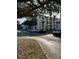 View of the condo building from the parking lot, with mature shade trees, sidewalks, and green spaces at 4024 Breakview Dr # 10804, Orlando, FL 32819