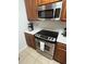 Stainless steel oven and microwave over matching brown cabinets in updated kitchen at 4024 Breakview Dr # 10804, Orlando, FL 32819