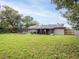 Large backyard showcasing the home, patio, mature trees, and trampoline at 412 Parson Brown Way, Longwood, FL 32750