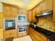 Kitchen featuring wooden cabinetry, granite countertops, and stainless steel appliances at 450 Blue Smoke Ct, Lake Mary, FL 32746