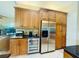 Kitchen featuring wood cabinetry, stainless steel appliances, granite countertops, and a wine fridge at 450 Blue Smoke Ct, Lake Mary, FL 32746