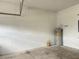 An empty garage featuring white walls, concrete flooring, a water heater and garage door hardware at 5768 Los Palma Vista Dr, Orlando, FL 32837