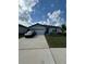 Charming single-story home with a two-car garage, landscaped yard, and concrete driveway at 597 Pine Tree Blvd, Lake Alfred, FL 33850