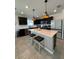 Stylish kitchen featuring a spacious island with pendant lighting and modern appliances at 597 Pine Tree Blvd, Lake Alfred, FL 33850