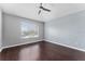 Serene bedroom with ceiling fan, dark wood floors, and a bright, sunny window at 607 Golden Dawn Ln, Apopka, FL 32712