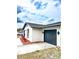 View of a one-story home highlighting the dark gray garage door and manicured landscaping at 616 Ivanhoe Way, Casselberry, FL 32707