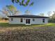 The backyard has a sliding glass door, a gray exterior, and a well-maintained lawn at 6425 Curtis St, Orlando, FL 32807