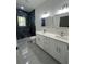 Bathroom featuring double sinks, vanity, and a modern shower with sleek tile at 6425 Curtis St, Orlando, FL 32807