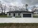 Single-story home featuring neutral stucco, dark roof, with two-car garage and concrete driveway at 6425 Curtis St, Orlando, FL 32807