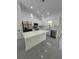Modern kitchen featuring white cabinets, stainless steel appliances, and a large island with a quartz countertop at 6425 Curtis St, Orlando, FL 32807