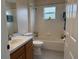 Bright bathroom featuring a bathtub and shower combination, vanity with sink, and tiled walls at 649 Gazelle Dr, Kissimmee, FL 34759