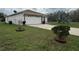 Exterior view of a single Gathering home featuring a front lawn with mature trees and a two-car garage at 649 Gazelle Dr, Kissimmee, FL 34759