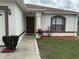 Close up of a home's exterior showcasing a decorative entry, flower beds, landscaping, and an arched window at 649 Gazelle Dr, Kissimmee, FL 34759