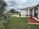 An angled side view of a home's exterior with a lawn, landscaping, and a columned entrance at 649 Gazelle Dr, Kissimmee, FL 34759