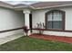 Close up shot of a home's exterior showcasing a columned entryway, flower beds, and a large window at 649 Gazelle Dr, Kissimmee, FL 34759