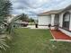 Home featuring manicured lawn, tidy mulch beds, and a quaint arched window at 649 Gazelle Dr, Kissimmee, FL 34759