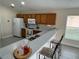 Bright kitchen featuring tile floors, white appliances, ample counter space, and a breakfast bar with seating at 649 Gazelle Dr, Kissimmee, FL 34759