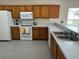 This kitchen offers tile floors, wood cabinets, white appliances, and ample countertop space for meal preparation at 649 Gazelle Dr, Kissimmee, FL 34759