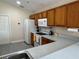Bright kitchen featuring tile floors, white appliances, and wood cabinetry with updated fixtures and finishes at 649 Gazelle Dr, Kissimmee, FL 34759