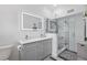 Modern bathroom featuring dual sinks, lit mirrors, and glass shower with mosaic accents at 701 Denton Rd, Winter Park, FL 32792