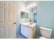 Cozy bathroom featuring a white vanity with a sink, toilet, and a framed mirror with light fixtures at 7147 Yacht Basin Ave # 115, Orlando, FL 32835