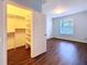 Bedroom with wood floors, window with blinds, walk-in closet, and ensuite bathroom at 7147 Yacht Basin Ave # 115, Orlando, FL 32835