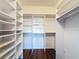 Large walk-in closet with built-in shelves and hanging rods at 7147 Yacht Basin Ave # 115, Orlando, FL 32835