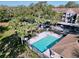 Community pool surrounded by lush landscaping, lounge chairs, and shaded parking at 7147 Yacht Basin Ave # 115, Orlando, FL 32835