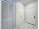 Well-lit hallway with closet, storage, and tile flooring leads to the main entrance at 7147 Yacht Basin Ave # 115, Orlando, FL 32835