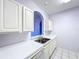 Bright kitchen with stainless steel sink, white cabinets, and a charming arched window at 7147 Yacht Basin Ave # 115, Orlando, FL 32835