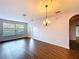 Spacious living room features wood flooring, chandelier lighting, and natural light at 7147 Yacht Basin Ave # 115, Orlando, FL 32835