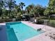 Community pool surrounded by lush greenery and mature trees at 7147 Yacht Basin Ave # 115, Orlando, FL 32835